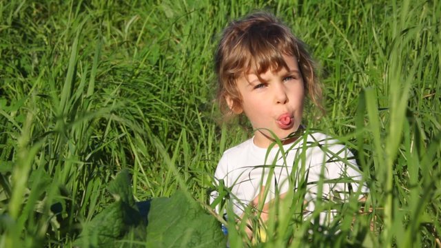 little girl making funny faces on meadow
