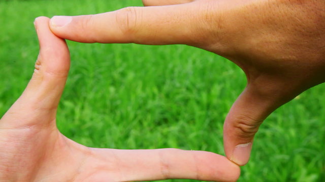 hands border on green grass background