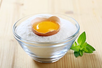 Fresh egg in a bowl of flour