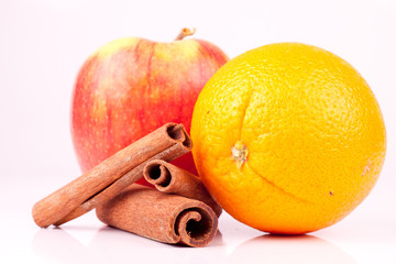 close up od orange, apple and cinnamon