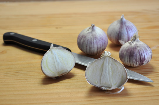 Neue Knoblauchsorte (Ackerlauch) mit Messer auf Schneidbrett