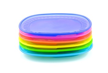 Stacked colorful plastic plates over white background