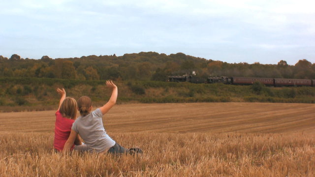 Children waving at a Steam train