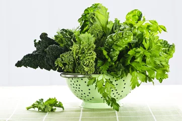 Crédence de cuisine en verre imprimé Légumes Légumes à feuilles vert foncé dans une passoire