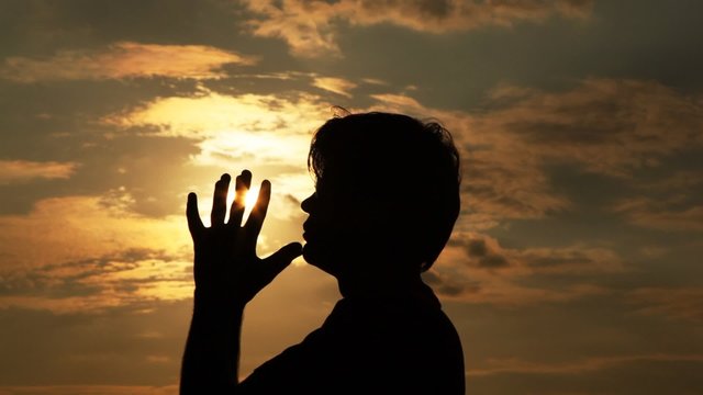 man spends hands by the sun and prays to it.