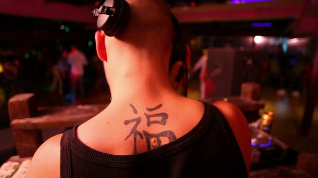 DJ from back and club on the background, fast mooving