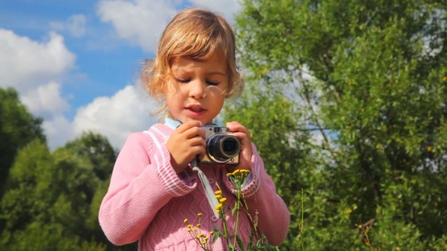 little girl with photo camera outdoor