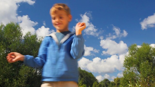 boy throwing up blue balloon in park