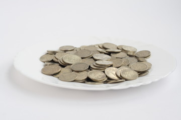 plate of coins isolated on white background