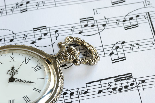 Antique pocket watch on the music sheet