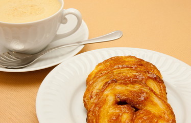 Closeup of coffee with milk in white cup and a palmier pastry