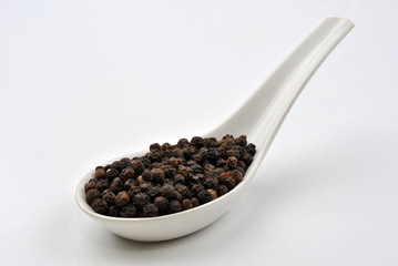 black organic pepper and a white background
