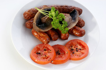 irish breakfast on a white plate with tomato