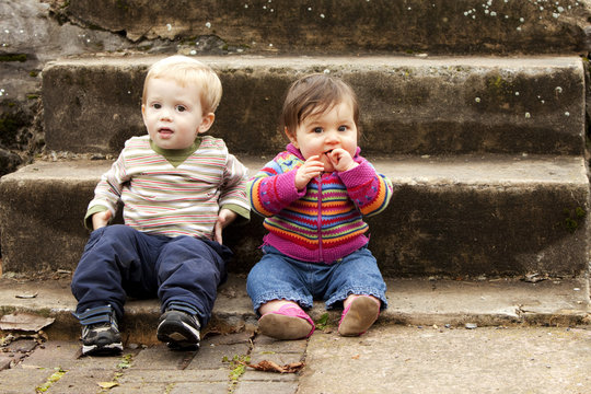 Two Young Children Hanging Out On Stairs