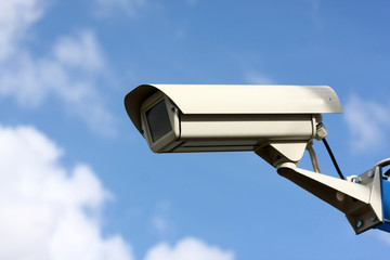 security video camera on background blue sky