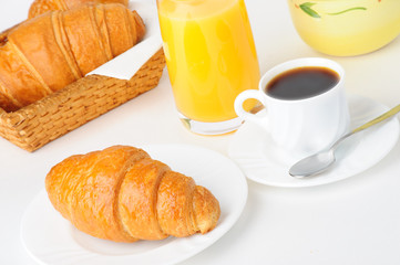 Cup of coffee with croissants and orange juice.