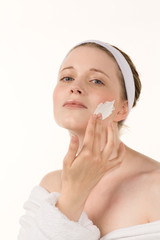 Frau cremt Gesicht ein, Wellness,