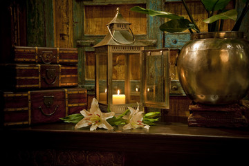 Candles burning on table in front of old rustic door