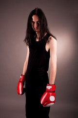serious gothic emo man in boxing gloves isolated on gray