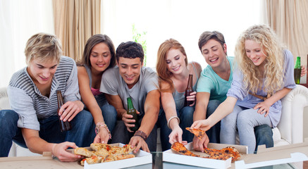 Teenagers eating pizza at home