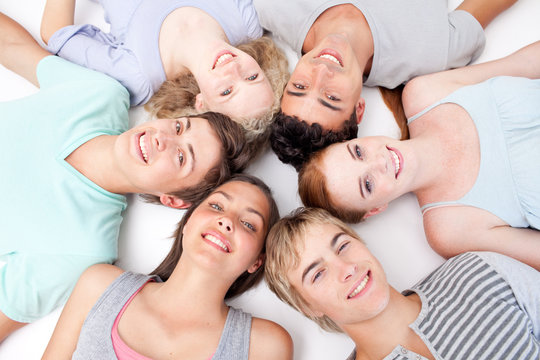 Teens lying on floor with heads together