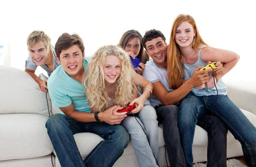 Teenagers playing video games at home