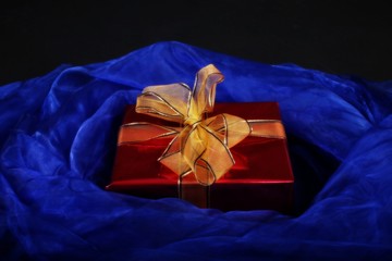 red present with gold bow on blue and black