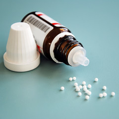 close-up of homeopathic globule pills with bottle
