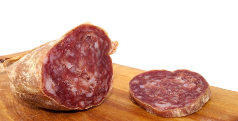 Closeup of italian typical salami and slice on wood trencher