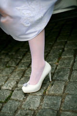 Wedding shoe bride emerging from the car after a trip