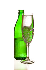 Mineral water bottle reflection in the full glass