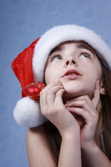 A portrait of girl is in the Christmas cap.