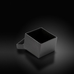 Boîte grise sur fond luxueux noir - paquet cadeau de luxe