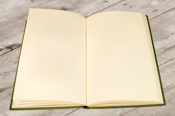 Open old book with blank pages (on a wooden surface)