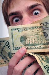 Man staring at a wad of cash