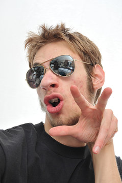 Young Man Sticking Tounge Out With Aviators