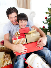 Obraz na płótnie Canvas Happy father and son holding Christmas presents