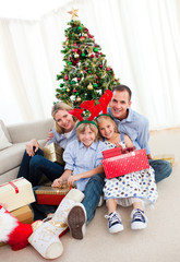 Obraz na płótnie Canvas Portrait of a smiling family holding Christmas presents