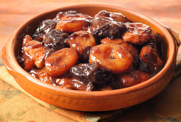 Dried fruits in syrup in terracotta dish