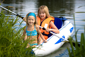 two young girls boating on the lake