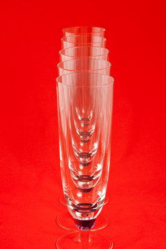 Five champagne glasses on red background