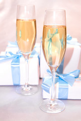Cute white gift boxes with blue ribbon ang champagne