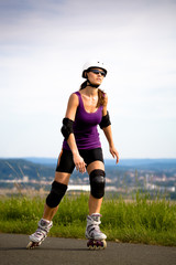 Young woman on rollerblades in the country