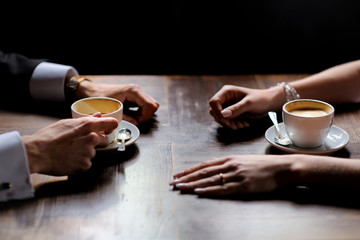 Bride's and groom's hands holding coffee cups
