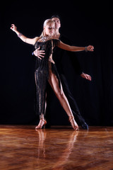 dancers in ballroom against black background