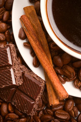 cup of coffee, beans, cinnamon and black chocolate