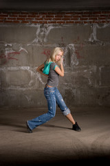 Obraz na płótnie Canvas Beautiful hip hop girl dancing over grey brick wall