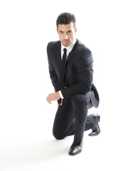 Business Mann kniet und schaut ernst