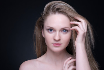 Fototapeta premium Close up portrait of beautiful blond girl on black