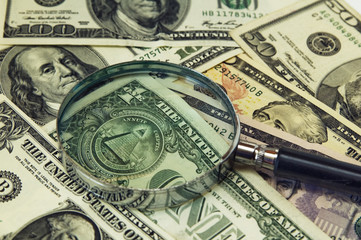 Background from dollar banknotes under a magnifier